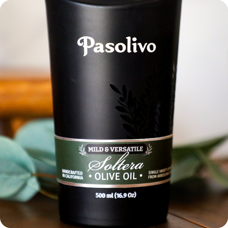 Pasolivo Soltera Olive Oil bottle on a wooden surface with a blurred background