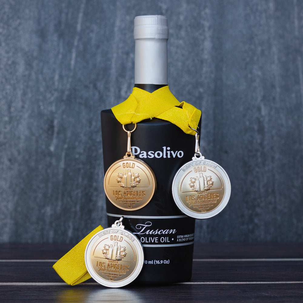 Bottle of Pasolivo Tuscan olive oil with three gold medals on a dark background