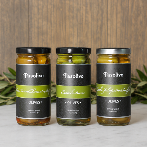 Three jars of Pasolivo olives on a wooden surface with olive branches in the background.